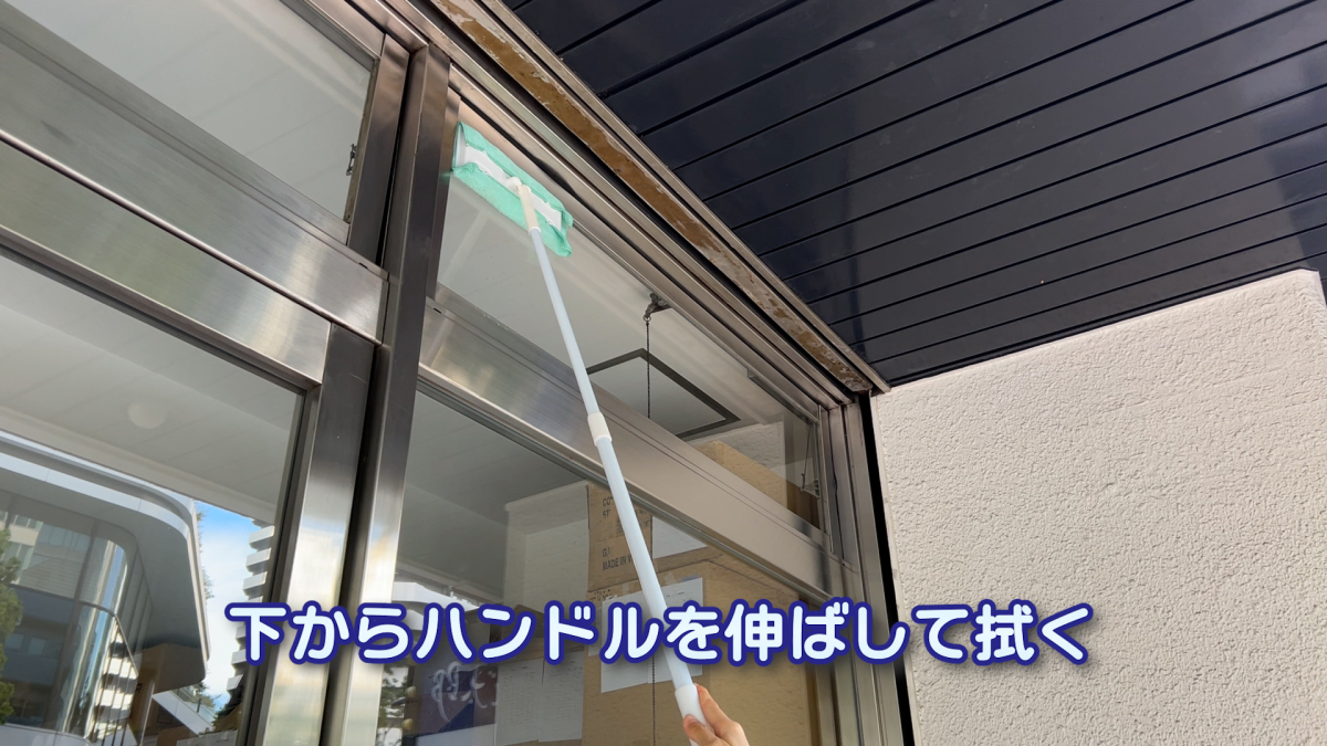 踏み台を使わずに高い窓を掃除しているイメージ